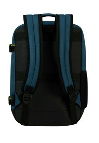 Zaino in tessuto blu e nero, dotato di spallacci imbottiti, due manici superiori e cinghie laterali regolabili. Costruzione resistente con hardware minimale.