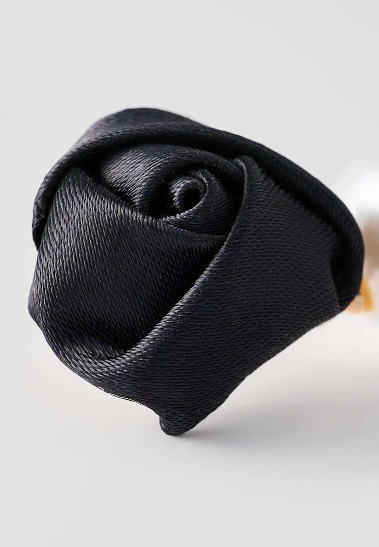 Rosa de satén negro, pétalos enrollados de forma compacta, textura suave, color vivo, con un detallado intrincado y un brillo sutil.