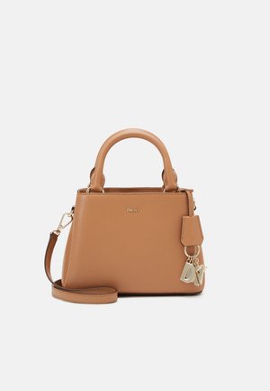 Beżowa skórzana torebka DKNY z uchwytami u góry, odpinanym paskiem na ramię oraz złotymi zawieszkami w kształcie liter DKNY po boku.
