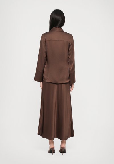 Brown satin blazer and maxi skirt set, featuring long sleeves, smooth texture, and a straight silhouette. Closed-back design.