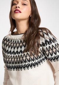 Sweter dziany z wzorzystym karczkiem w czarnym, beżowym i białym kolorze. Kremowe ciało z ozdobami wokół dekoltu. Długie rękawy.