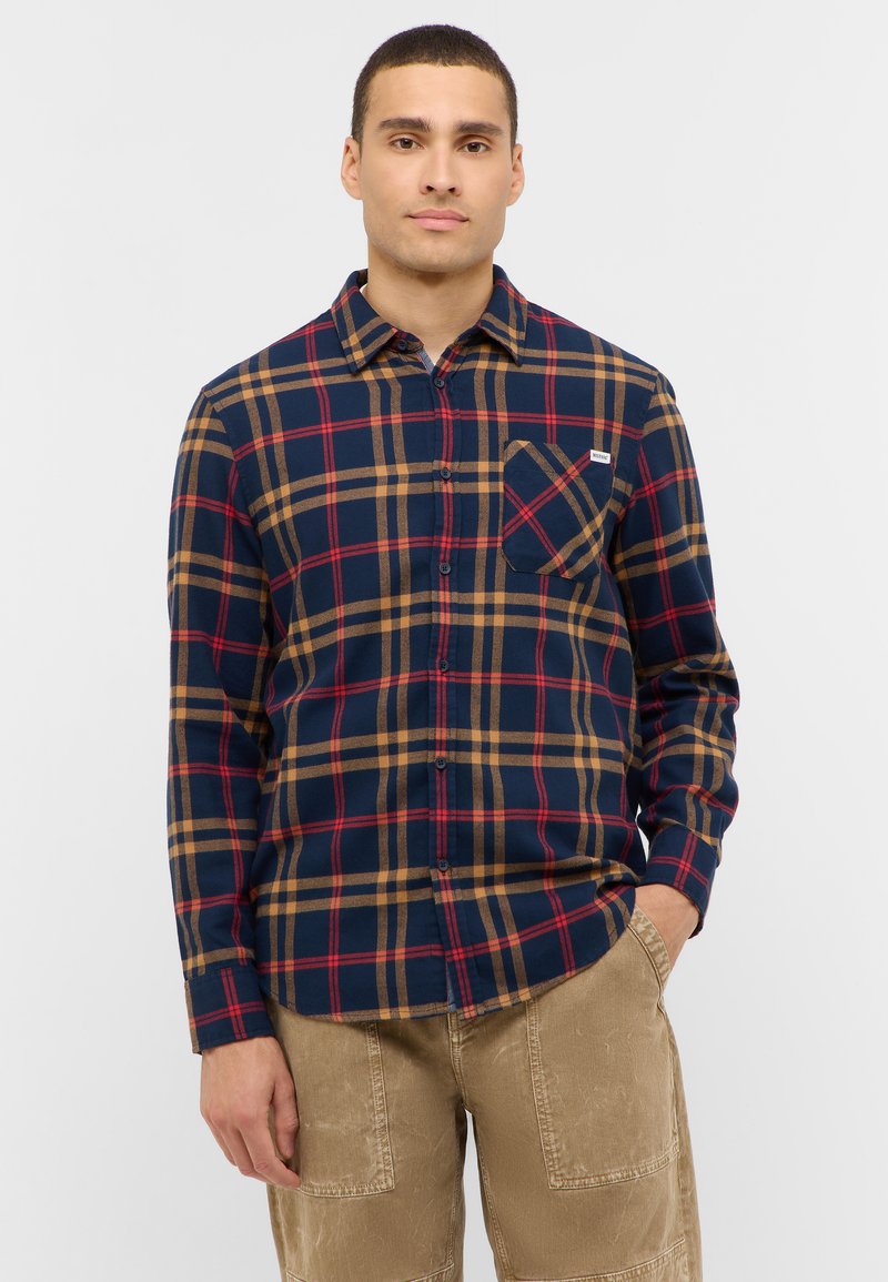 Marineblauw en beige geruite flanellen shirt met een button-down kraag, een borstzak en lange mouwen. Getextureerde stof met een relaxte pasvorm.