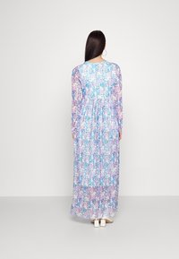 Długa, kwiecista sukienka z niebieskim tłem i różowymi oraz białymi kwiatami. Długie rękawy, marszczona talia i długość do podłogi.