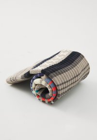 Gestreifte Strümpfe aus Wolle in Beige, Marineblau und Grau mit einem strukturierten Design und bunten Akzenten in Rot und Blau am Bündchen.