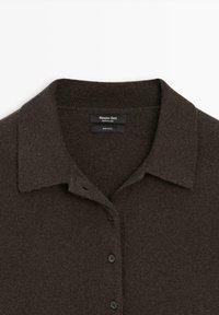 Brązowy sweter wełniany z kołnierzykiem, zapięciem na guziki i prążkowanymi akcentami przy kołnierzu. Metka głosi "Massimo Dutti" i "100% wełny."