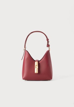 Rood leren handtas met een kenmerkende gebogen vorm, verstelbare schouderband en een goudkleurige sluiting aan de voorkant. Zachte textuur, minimalistisch ontwerp.