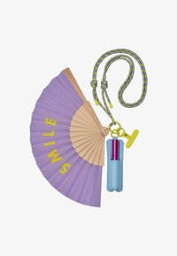Abanico plegable violeta con mango de madera que lleva la palabra "SONRÍE" en amarillo, unido a una funda azul que contiene un spray rosa, con una correa colorida.