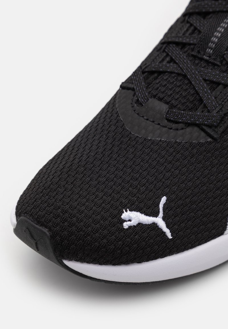 Zapatilla negra con parte superior de malla texturizada, con detalles del logotipo en blanco y cordones negros. La suela de goma ofrece durabilidad y tracción.