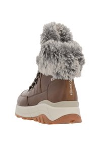 Brązowy skórzany but z szarym kołnierzem z sztucznego futra, sznurowany design, gruba biała podeszwa środkowa oraz kontrastowa gumowa podeszwa. Widoczna charakterystyczna etykieta marki.
