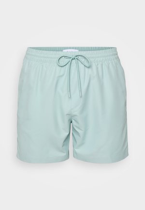 Shorts de bain bleu clair en matériau synthétique lisse, dotés d'une taille élastique avec cordon de serrage et de poches latérales.