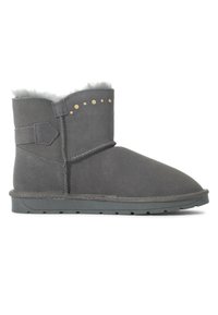 Botas de tobillo de ante gris con un suave forro de piel de oveja, que presentan tachuelas doradas decorativas, una correa lateral y una suela plana y texturizada.