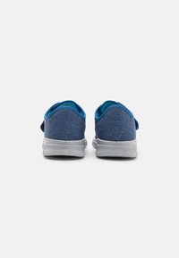 Niebieskie buty z materiału o teksturowym wzorze, z szarym spodem i jaskrawo-niebieskim wykończeniem wokół otworu oraz zapięciem na rzep.