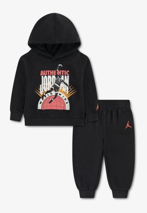 Ensemble sweat à capuche noir et pantalon avec un graphisme d'un joueur de basket sautant avec un ballon au-dessus d'un globe orange et le texte "Authentic Jordan".