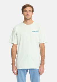 Lichtgroene katoenen t-shirt met een ronde hals, korte mouwen en een blauwe "SPYDER" logo op de linkerkant van de borst. Glad textuur, ontspannen pasvorm.