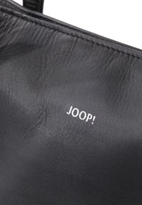 Sac en cuir noir avec une texture lisse, arborant un logo "JOOP!" blanc affiché en évidence. Le design est minimaliste avec des bords nets.