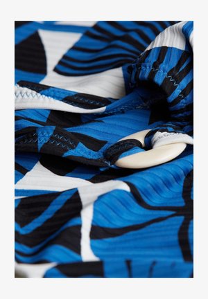 Tkanina za kupaće kostime s apstraktnim uzorcima u plavoj i crnoj boji, s bijelim akcentima. Uključuje veliki, glatki gumb i vidljive šavove.