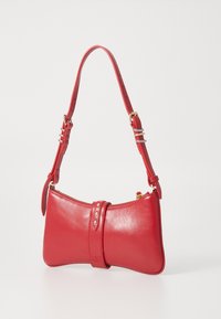 Red leather handbag with a curved, bow-like shape. Features a zip closure, decorative band, and gold hardware accents. Adjustable strap.