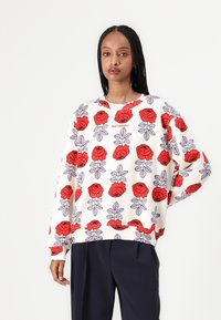 Red and purple floral patterned sweatshirt with a cream background, featuring a round neck and cuffed sleeves, made from cotton blend material.