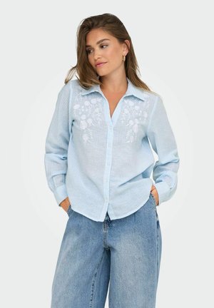 Light blue striped button-up shirt with white floral embroidery on the chest, featuring a collar and long sleeves. Relaxed fit design.