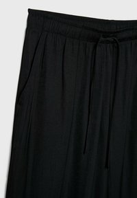 Schwarze, leichte Hose mit elastischem Bund und Kordelzug, ausgestattet mit Seitentaschen und einer weichen, glatten Textur.