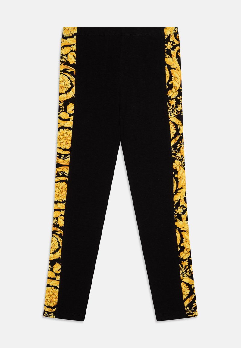 Leggings pretos com um design floral amarelo ao longo das costuras laterais externas. Material macio com um formato ajustado e cintura elástica.