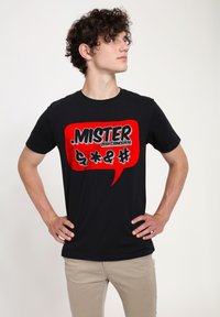 Černé bavlněn�é tričko s výrazným červeným grafickým textem "MISTER ZEEK@SINCE1976" a symboly v designu bubliny s textem.