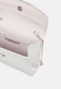 Srebrna metaliczna kopertówka z teksturowaną powierzchnią, kieszenią wewnętrzną i łańcuszkowym paskiem. Zapięcie na zatrzask z miękką różową podszewką.