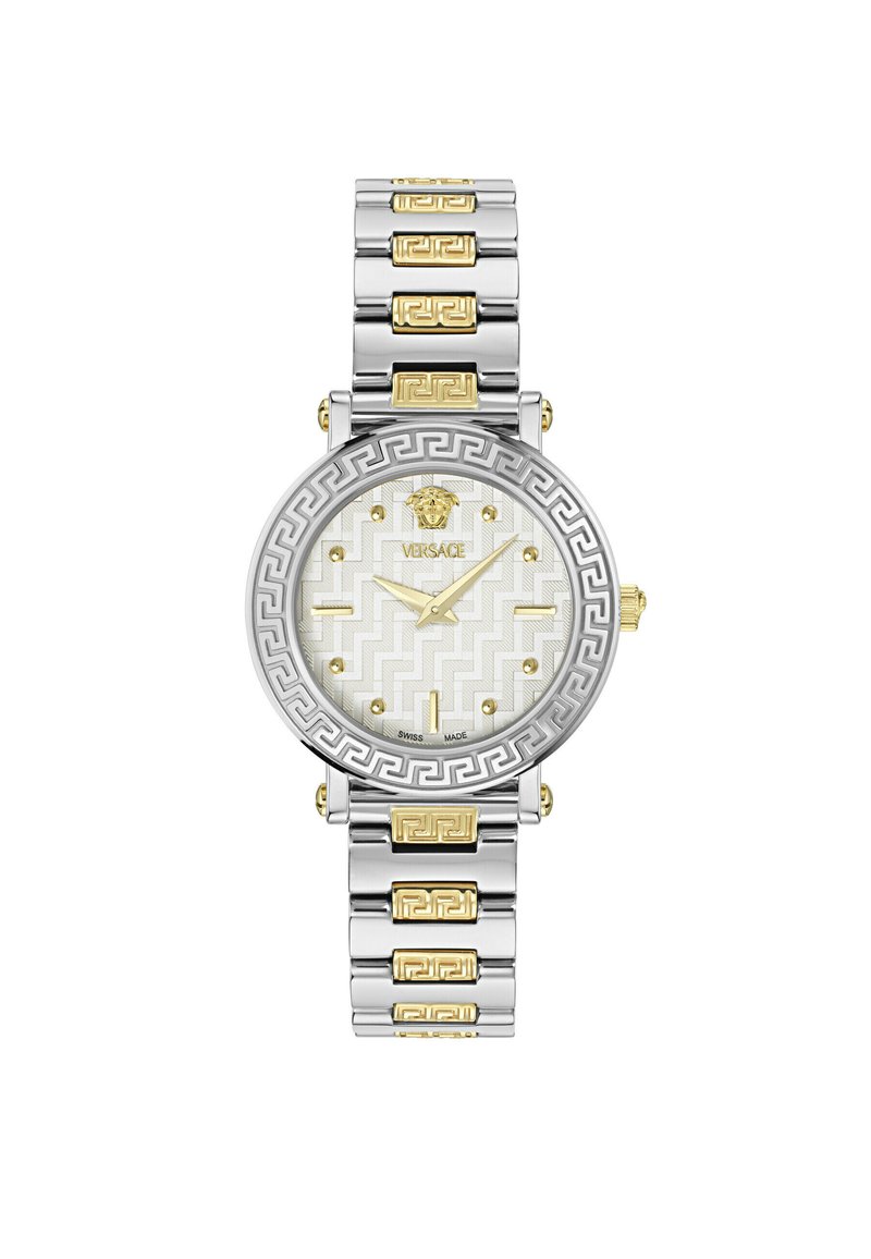 Sudraba un zelta tonī tērauda pulkstenis ar apaļu seju, baltu rakstainu ciparnīcu un grieķu atslēgas dizaina aksesuāriem uz rokassprādzes.