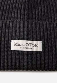 Tmavo šedá pletená čiapka s vertikálnym ryhovaním. Obsahuje bielu nálepku so zašitým textom "Marc O’Polo" a "EST. V STOCKHOLME" v čiernej farbe.