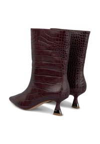 Botas de tobillo burdeos en cuero con textura de cocodrilo grabada, con puntera afilada y un tacón delgado con un acento negro en contraste.
