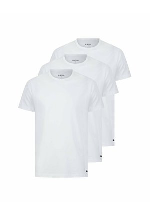 Drei einfache weiße T-Shirts aus Baumwolle mit einem standardmäßigen Rundhalsausschnitt. Jedes Shirt verfügt über ein Logo-Tag auf der unteren linken Seite.