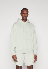 Light green hoodie made of soft cotton, featuring a kangaroo pocket and drawstring hood. Includes a small embroidered logo on the chest.