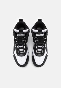 Černobílé vysoké tenisky se strukturovaným koženým svrškem, vyztuženou špičkou a plochými černými tkaničkami. Logo PUMA na jazyku.