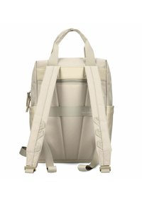 Zaino in tessuto beige con tasca a zip orizzontale, spallacci imbottiti e due manici superiori; presenta una texture liscia e un design minimalista.