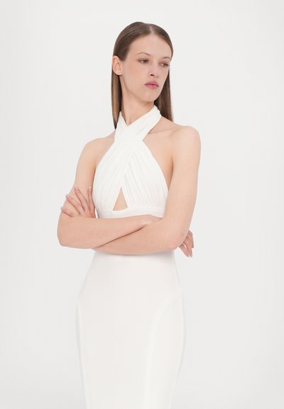 Vestido blanco sin mangas con tejido cruzado en el escote, que presenta un corte destacado y una silueta ajustada. Textura suave.