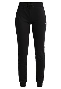 Zwarte sweatpants van zachte stof, voorzien van een elastische tailleband met trekkoord, taps toelopende pijpen en geribbelde boorden. Klein logo detail.