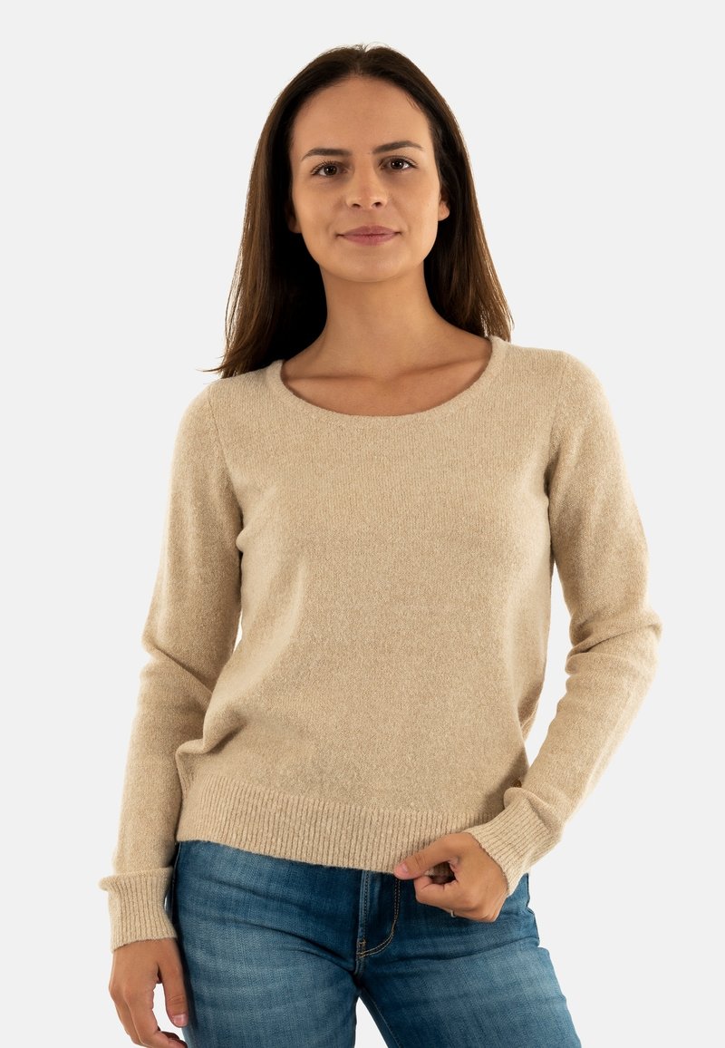 Maglione beige a maglia con colletto rotondo e polsini e orlo a costine. Texture morbida, vestibilità rilassata. Abbinato a jeans in denim blu.