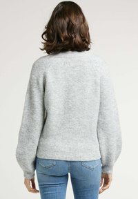 Pull gris à côtes avec un col rond et des manches ballon. Fabriqué en matériau doux, doté d'une taille ajustée et d'un tissu texturé.
