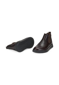 Bottines Chelsea en cuir brun avec une surface texturée, des panneaux latéraux élastiques et une semelle en caoutchouc noir. Présente une pointe ronde et un design à enfiler.