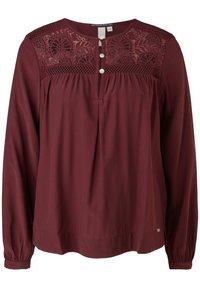 Bordeauxfarbene Langarmbluse mit Spitzeneinsatz, Knopfleiste und Raffung am Saum. Weicher Stoff mit entspannter Passform.