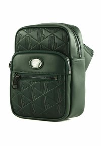 Mørkegrøn Lacoste crossbody taske med præget geometrisk mønster, frontlomme med lynlås, sølvlogo og hovedlynlåslukning.