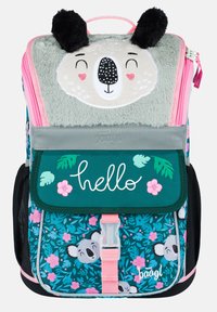 Batoh s texturovaným šedým klopou, která zobrazuje obličej medvěda, růžovými akcenty, květinovými vzory a přední kapsou s nápisem "ahoj" v bílé barvě.