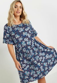 Blommig klänning i marinblått med vita och blå blommor, korta ärmar, rund halsringning och veckad midja för en avslappnad passform.