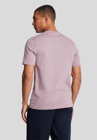 T-shirt a maniche corte con colletto rotondo in lavanda chiaro, realizzato in morbido tessuto di cotone, con vestibilità regolare e dettagli di cucitura minimi.