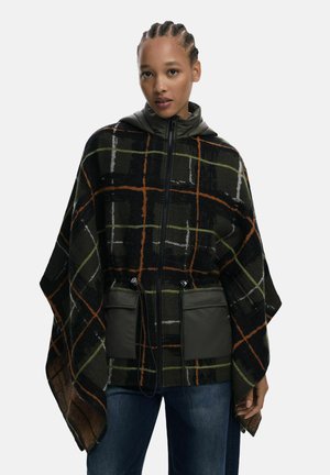 Poncho in a plaid pattern featuring dark green, orange, and white. Includes a zip closure and two front pockets with a smooth finish.