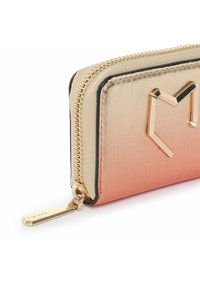 Portafoglio con gradiente dorato e effetto ombré rosa, texture in pelle, chiusura con zip e un accento a forma di cuore dorato sul fronte. Dettagli in hardware dorato.