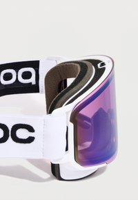 Slidiniai akiniai su purpurine objektyvo spalva, balta kaušeliu ir juodu reguliuojamu dirželiu su "POC" logotipu. Putų paminkštinimas aplink objektyvą komfortui.