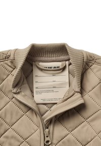 Beżowa pikowana kurtka z prążkowanym kołnierzem i zamkiem błyskawicznym, wyposażona w wewnętrzną metkę z miejscem na wpisanie imienia oraz ulubionego miejsca do ukrycia się.