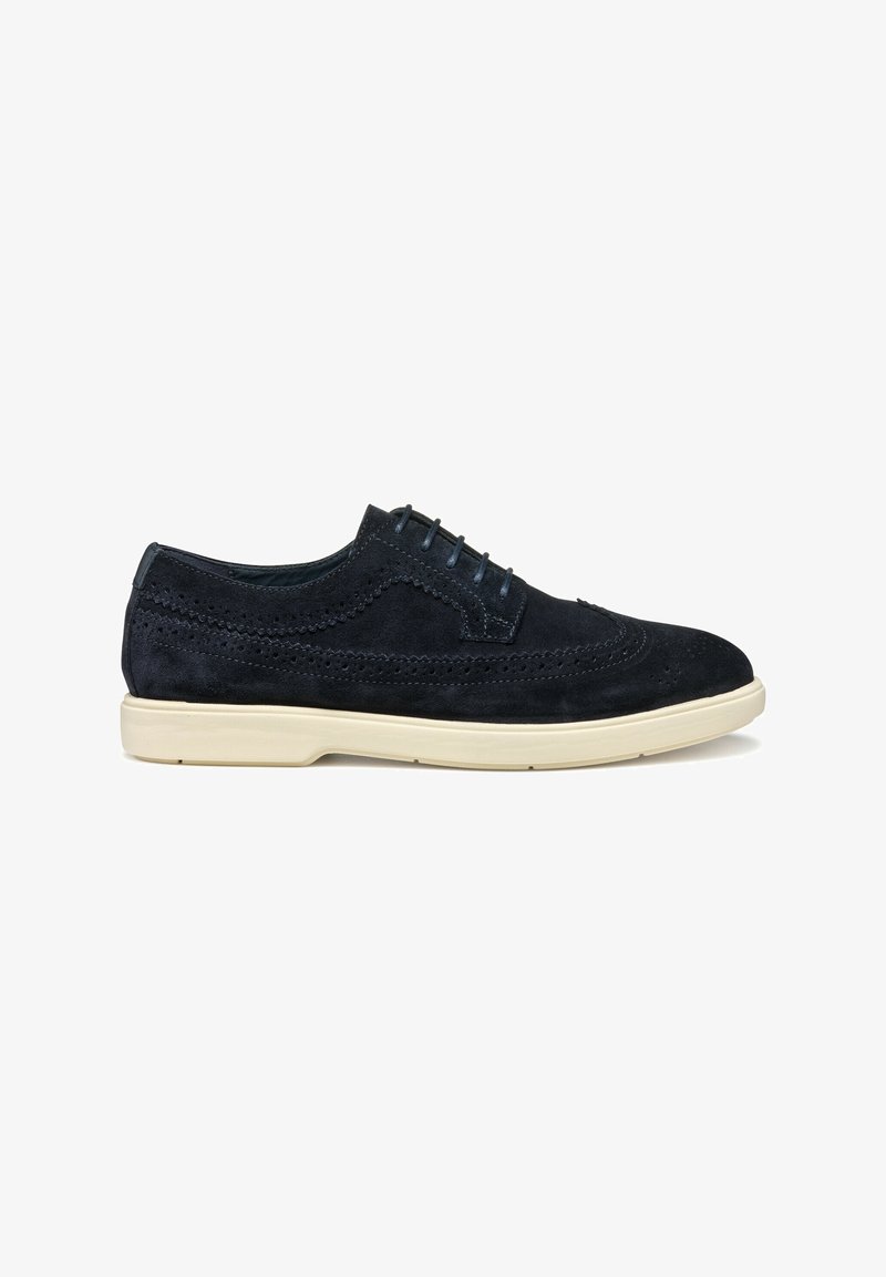 Scarpe in suede blu scuro con lacci, dettagli brogue e suola in gomma beige chiaro. Presentano accenti testurizzati sulla tomaia.
