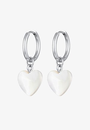 Zilveren oorringen met witte, hartvormige hangers tegen een witte achtergrond.